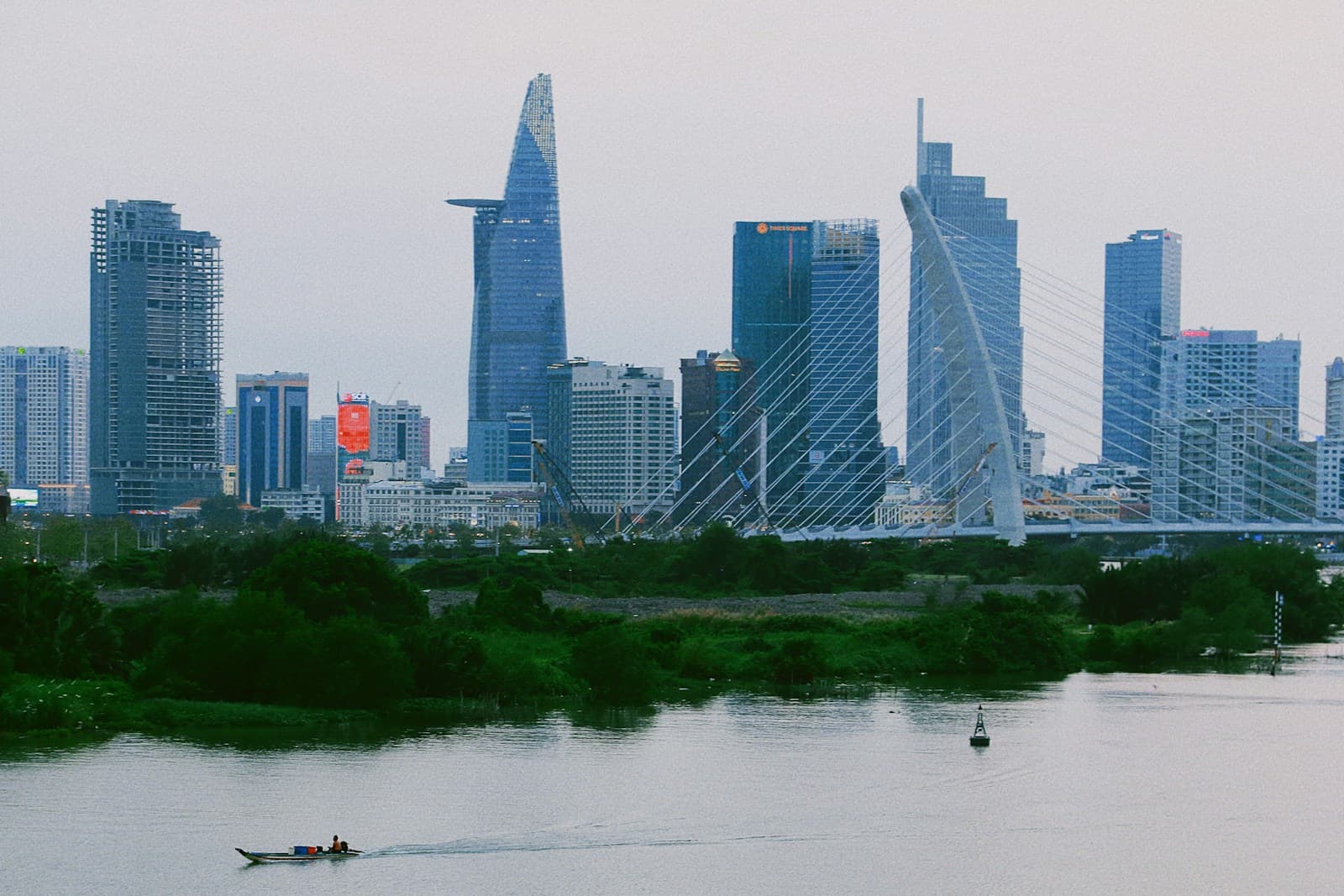 A boat on the Saigon River with the Ho Chi Minh City skyline in the background